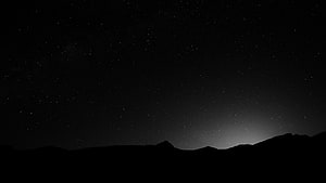 Monochrome Starry Night Sky Over Silhouetted Mountain Range HD wallpaper