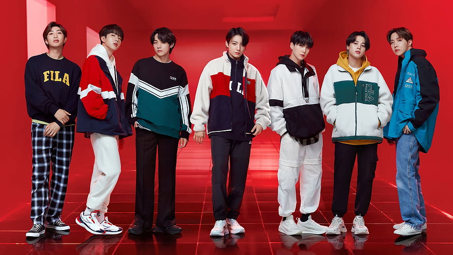 BTS Members in Colorful FILA Streetwear Against a Vibrant Red Studio Backdrop HD wallpaper