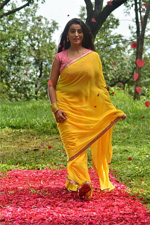 Akshara Singh in a Vibrant Yellow Saree Walking Through a Garden of Rose Petals HD phone wallpaper