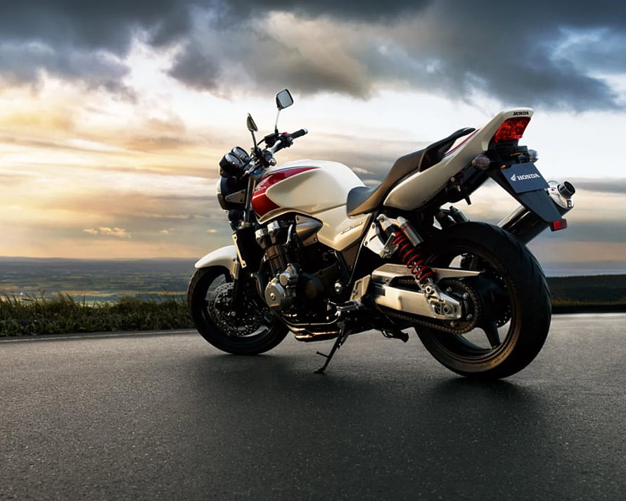 Honda CB1300 Super Four motorcycle parked on a scenic road at sunset HD wallpaper