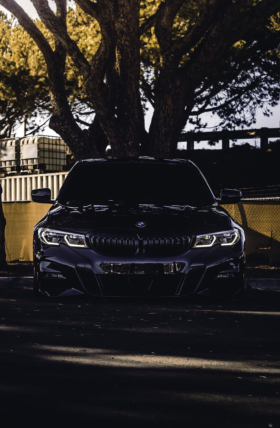Black BMW 330i G20 Front View Under Tree With Dramatic Lighting HD phone wallpaper