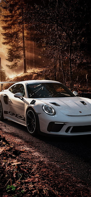White Porsche 911 GT3 RS parked on a forest road at golden hour with dramatic backlighting HD phone wallpaper