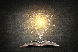 Glowing Lightbulb Above Open Book on Chalkboard with Mathematical Equations HD wallpaper
