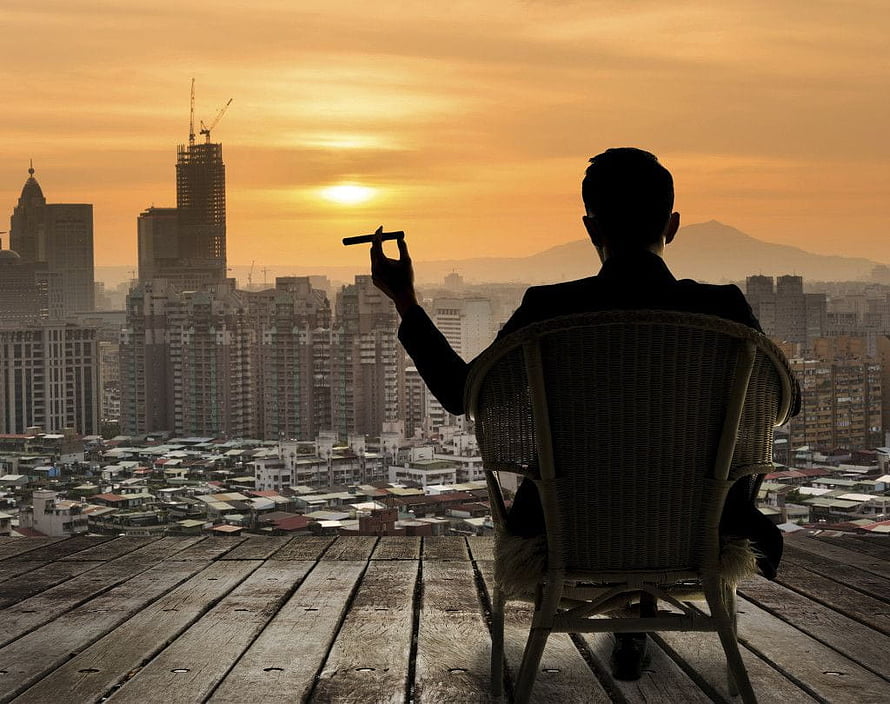 Silhouette of a man in a suit holding a cigar on a rooftop overlooking a city skyline at sunset, Billionaire Luxury Lifestyle posted by Ryan Walker, billionaire lifestyle HD wallpaper
