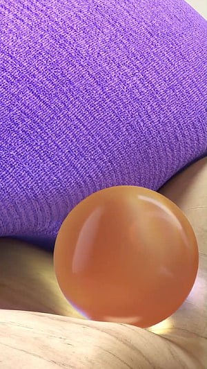 Glossy Amber Sphere Resting on Purple Knit Fabric and Light Wood Surface HD phone wallpaper