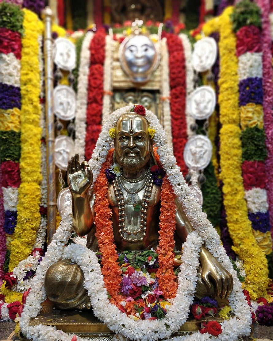 Guru Raghavendra Swamy Murti Adorned With Vibrant Flower Garlands In Temple Setting HD phone wallpaper