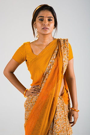 Vani Bhojan in a vibrant orange and floral saree with gold bangles HD phone wallpaper