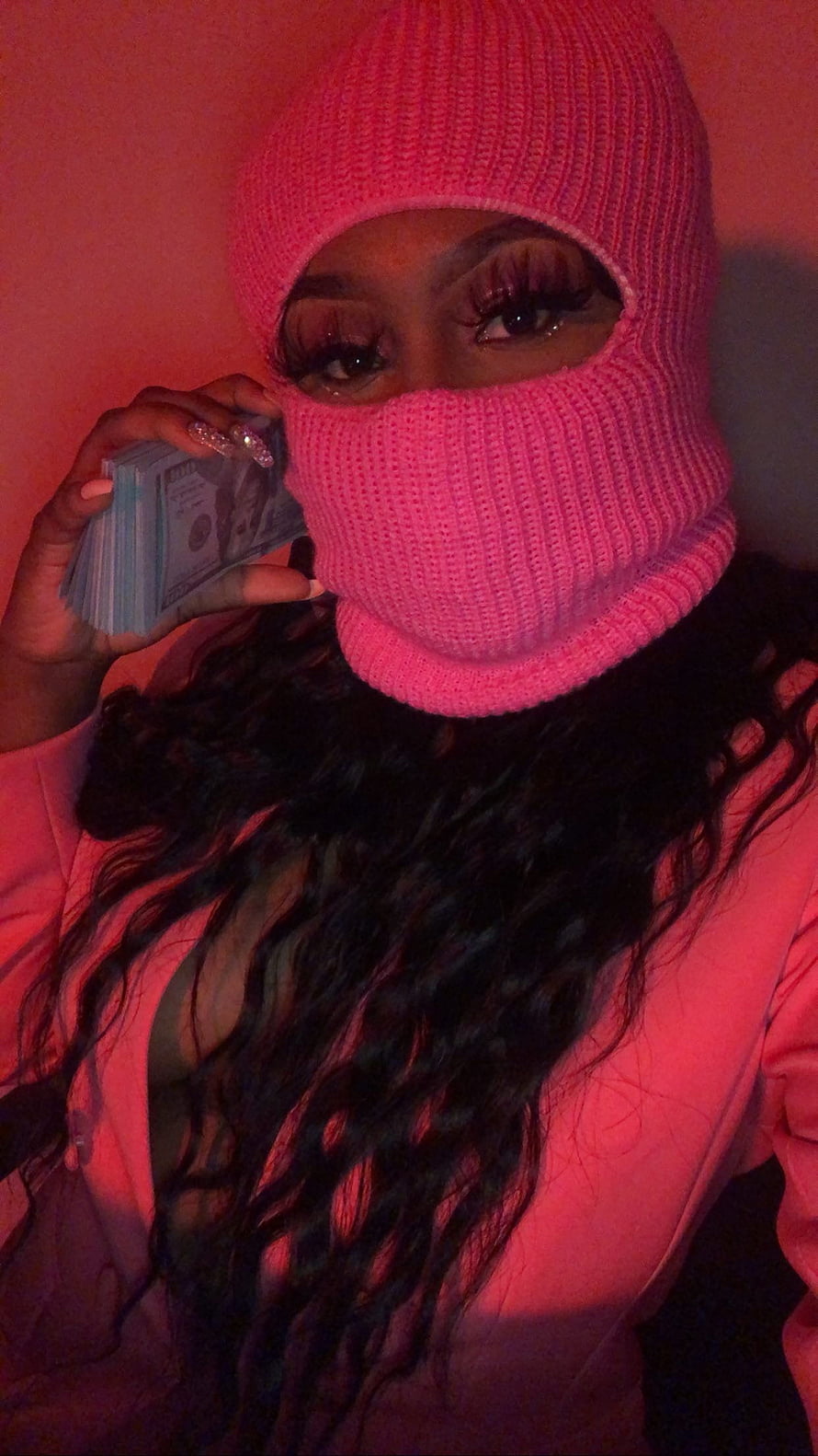 Woman in pink knit balaclava holding cash under red lighting HD phone wallpaper