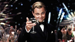 Leonardo DiCaprio as Jay Gatsby in The Great Gatsby holding a champagne glass at a lavish party HD wallpaper