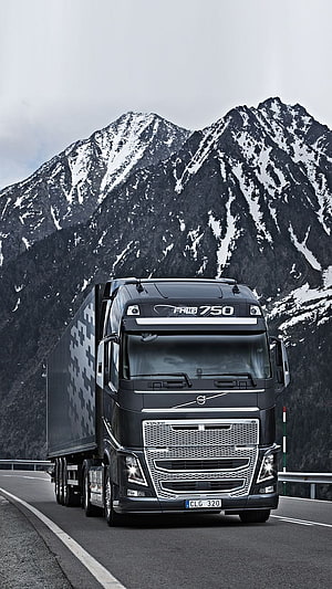 Volvo FH16 750 Heavy Duty Truck Driving on Mountain Highway with Snowy Peaks HD phone wallpaper
