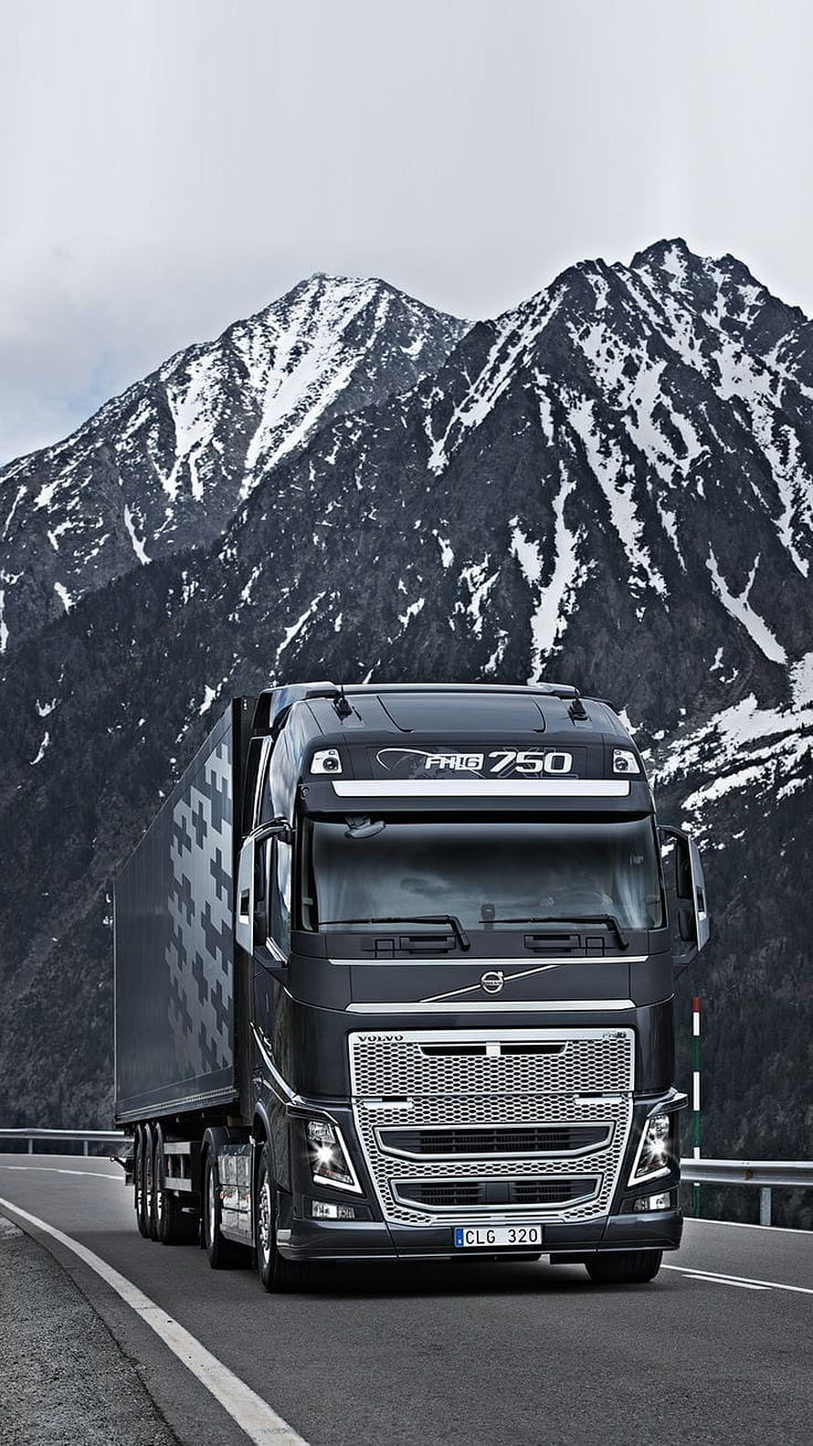 Volvo FH16 750 Heavy Duty Truck Driving on Mountain Highway with Snowy Peaks HD phone wallpaper