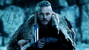 Ragnar Lothbrok in Fur Cloak Holding Sword in Snowy Forest HD wallpaper