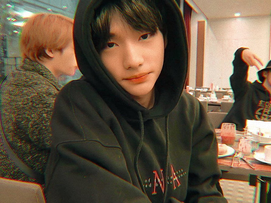 Hwang Hyunjin of Stray Kids in a black hoodie at a casual indoor gathering HD wallpaper