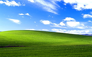 Rolling Green Hills Under a Bright Blue Sky with Scattered Clouds HD wallpaper
