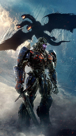 Optimus Prime in Dark Armor Confronting a Three-Headed Dragon in a Fantasy Battle Scene HD phone wallpaper