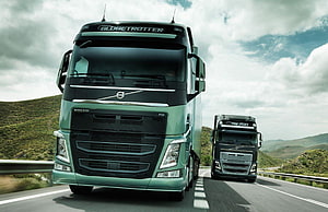 Volvo FH16 Globetrotter Heavy-Duty Trucks Cruising on a Mountain Highway HD wallpaper