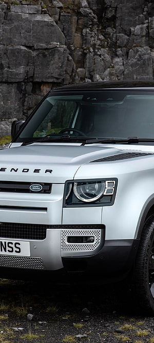 Silver Land Rover Defender 90 SE Urban Pack Front Close-Up Against Rocky Cliffs HD phone wallpaper
