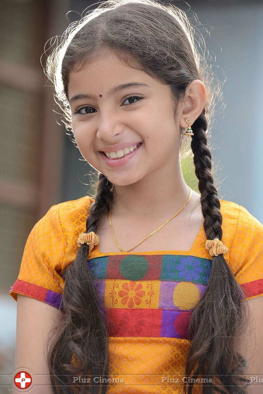 Sara Arjun in a colorful patchwork top with braided hair and a warm smile HD phone wallpaper