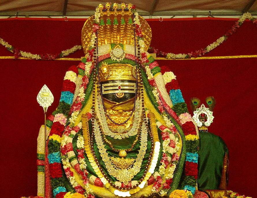 Annamalaiyar deity adorned with vibrant flower garlands and gold ornaments at Thiruvannamalai temple HD wallpaper