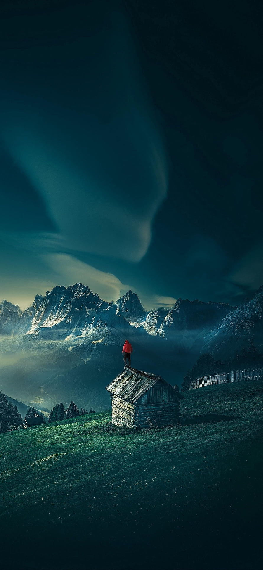 Lone Hiker on Alpine Cabin Roof with Dramatic Mountain Peaks and Misty Valley HD phone wallpaper