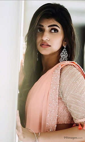 Sree Leela in a peach embroidered saree with long dark hair and ornate jhumka earrings HD phone wallpaper