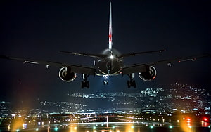 Commercial Jetliner Approaching Runway at Night Over Illuminated City HD wallpaper