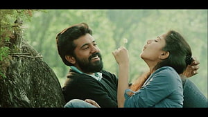 Malare Premam Movie Still: Romantic Couple Sharing a Dandelion in a Lush Forest HD wallpaper