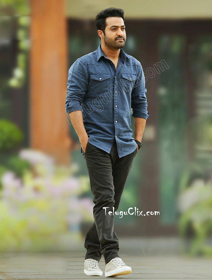 JR NTR in a blue denim shirt and black trousers standing outdoors with a relaxed pose HD phone wallpaper