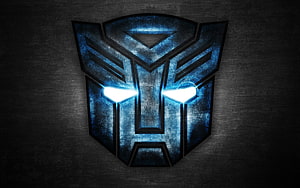 Glowing Autobot insignia with illuminated eyes on a dark textured metal background HD wallpaper