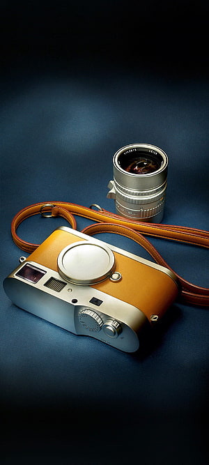 Leica M6 Rangefinder Camera with Detached Lens and Leather Strap on Dark Blue Surface HD phone wallpaper