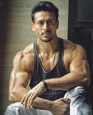Tiger Shroff Muscular Portrait in Black Tank Top and Grey Jeans HD phone wallpaper
