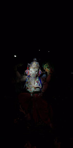 Lord Ganesha Murti Illuminated Against a Dark Night Sky HD phone wallpaper