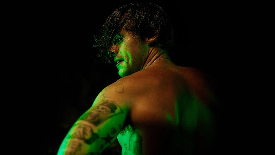 Harry Styles in Dramatic Green Stage Lighting with Visible Tattoos HD wallpaper