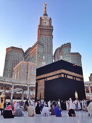 The Kaaba in Makkah with the Makkah Clock Tower and pilgrims in prayer HD phone wallpaper