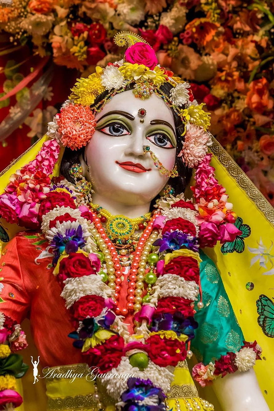 Adorned Radha Krishna Murti with Vibrant Floral Garlands and Traditional Jewelry HD phone wallpaper