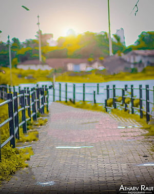 Serene Riverside Walkway at Golden Hour with Metal Railings and Lush Greenery HD phone wallpaper