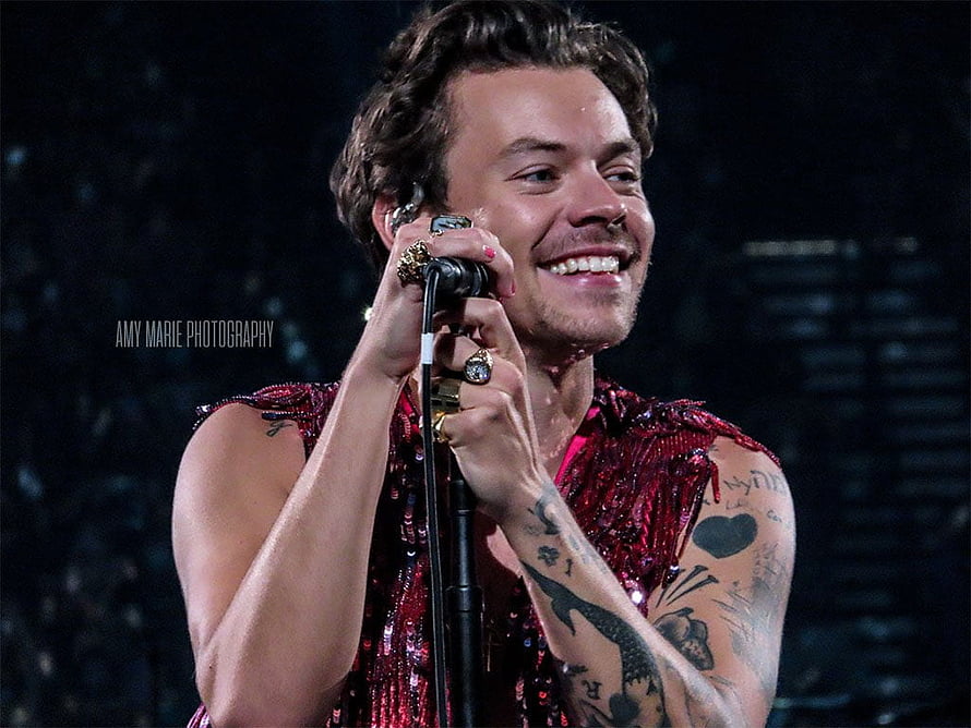 Harry Styles performing on stage in a red sequined outfit with microphone HD wallpaper