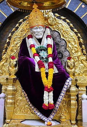 Sai Baba of Shirdi seated on ornate golden throne with purple robe and flower garlands HD phone wallpaper