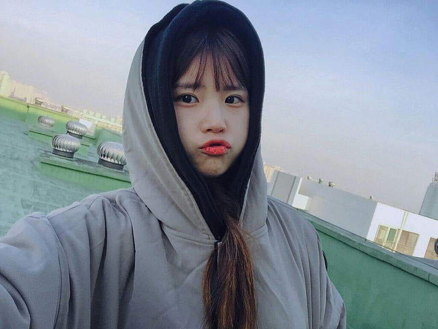 Song Hayoung in a grey hoodie on a rooftop with a playful expression HD wallpaper