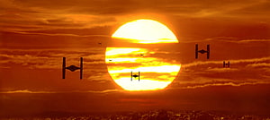 Star Wars TIE Fighters Silhouetted Against a Massive Orange Sunset Sky HD wallpaper