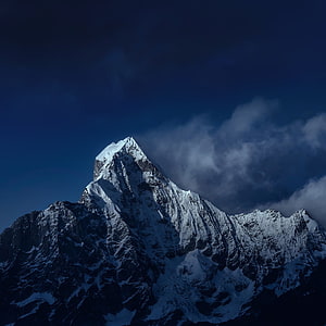 Majestic Snow-Capped Mountain Peak Rising Against a Deep Blue Twilight Sky HD phone wallpaper