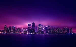 Vibrant Purple Skyline at Night with City Lights Reflecting on Water HD wallpaper