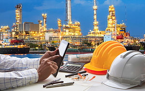Oil and Gas Industry Engineering Workspace with Hard Hats and Tablet HD wallpaper