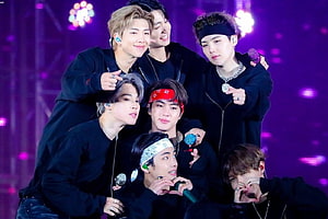 BTS Members Posing Together On Stage With Purple Lighting And Microphones HD wallpaper