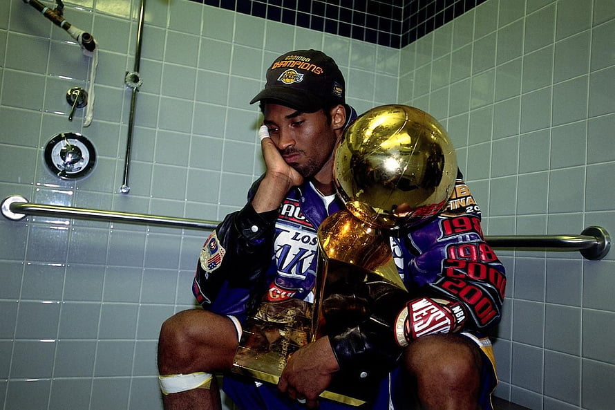 Kobe Bryant holding the NBA championship trophy in a locker room after a Lakers title win HD wallpaper