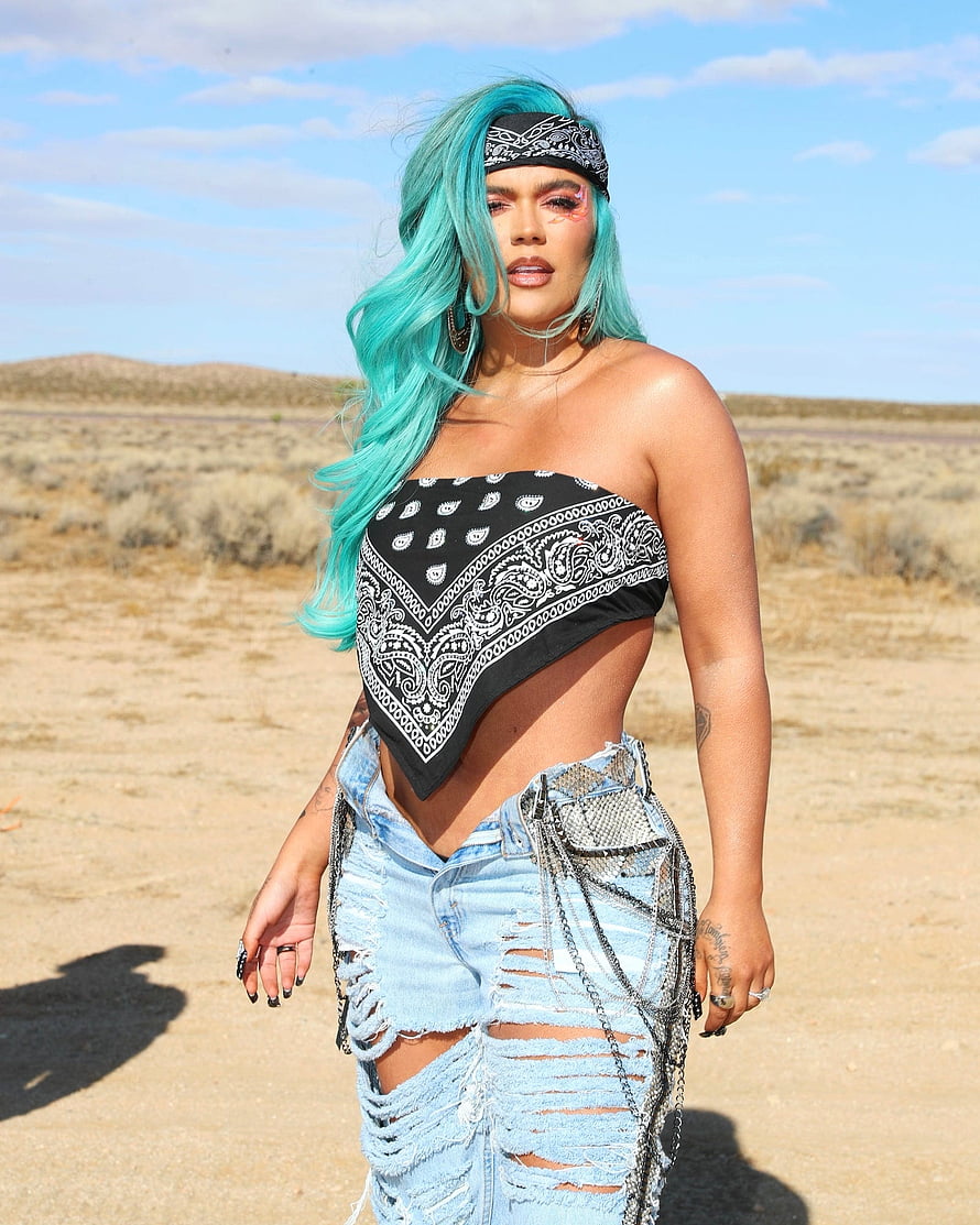 Karol G in Turquoise Hair and Bandana Outfit in Desert Landscape HD phone wallpaper