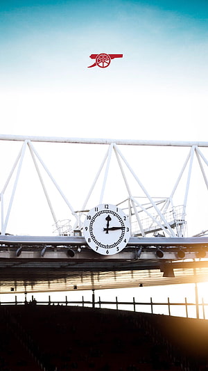 Arsenal Stadium Clock and Cannon Logo Against a Bright Sky HD phone wallpaper