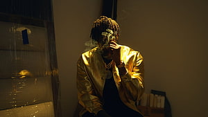 NBA YoungBoy in Gold Jacket Smoking in Moody Studio Setting HD wallpaper