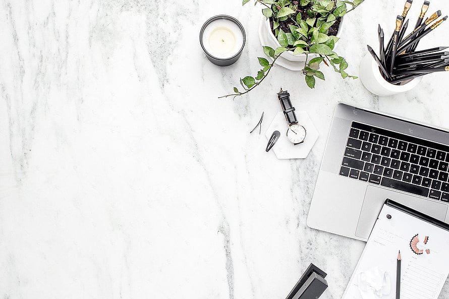 Minimalist White Marble Workspace With Laptop, Plant, And Candle HD wallpaper