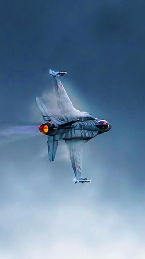 General Dynamics F-16 Fighting Falcon performing a high-speed maneuver with visible vapor cone HD phone wallpaper